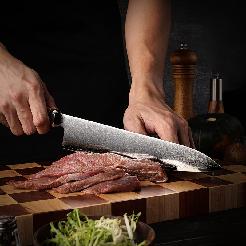 Person cutting raw meat on a wooden cutting board with a dark background