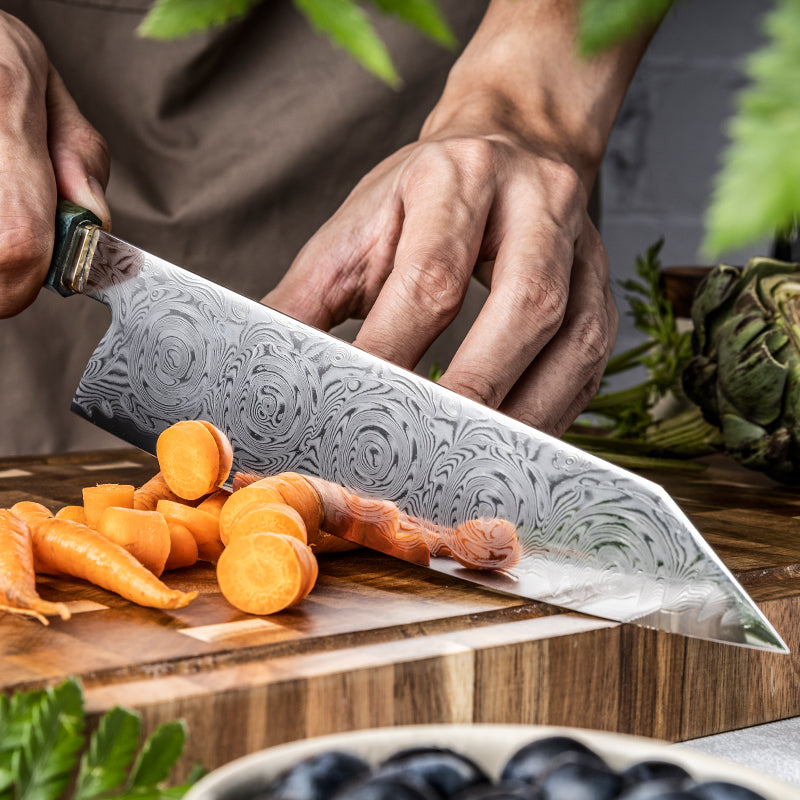 Person cutting carrots with a decorative kiritsuke knife on a wooden surface