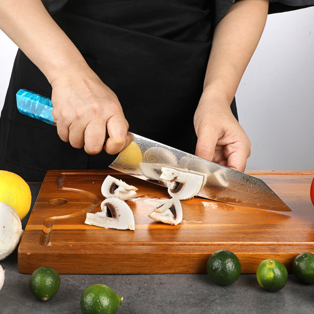 Person cutting mushrooms on a wooden board with a knife, surrounded by limes and a lemon.