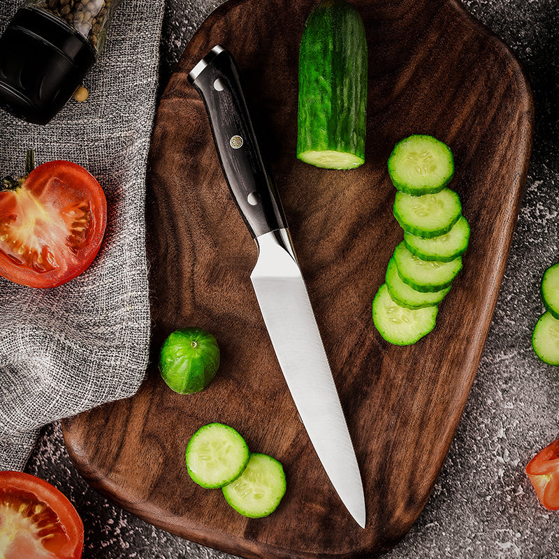 Sliced cucumbers and a hikari knife kitchn knife with german steel blade on a wooden cutting board with tomatoes and a gray cloth.