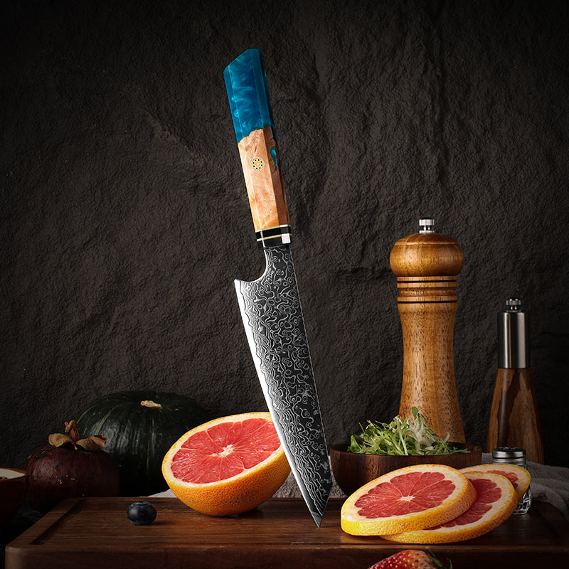 Small Petty japanese knife with a decorative handle on a wooden cutting board with fruits and a pepper grinder.