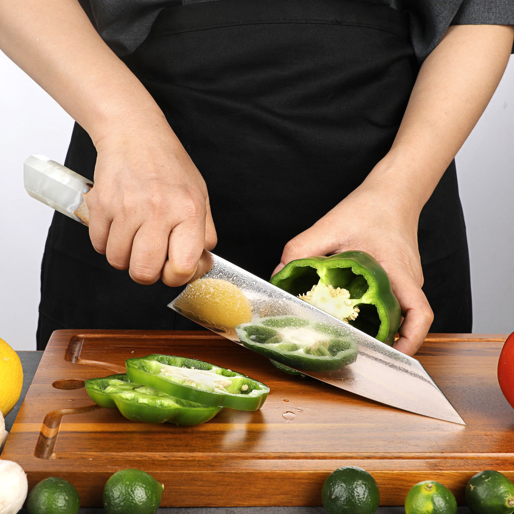 Person cutting green bell pepper on a wooden cutting board with a knife.