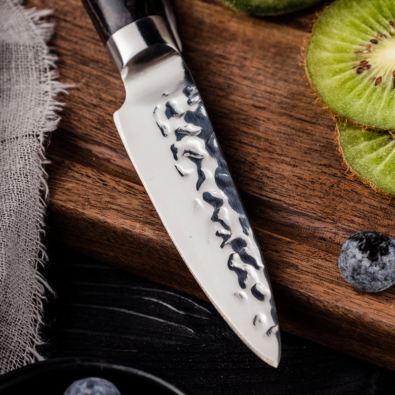 Decorative chef's knife on a wooden cutting board with sliced kiwi