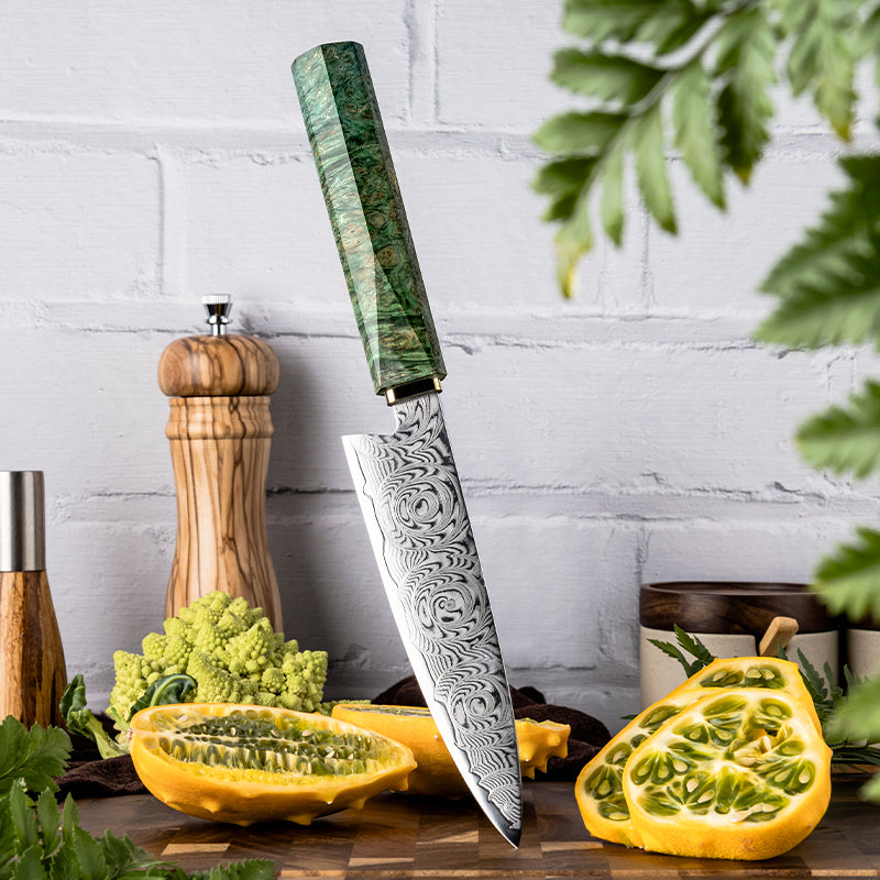 Decorative utility knife with ROSE DAMASCUS PATTERN blade with green handle on a wooden cutting board with vegetables and plants.
