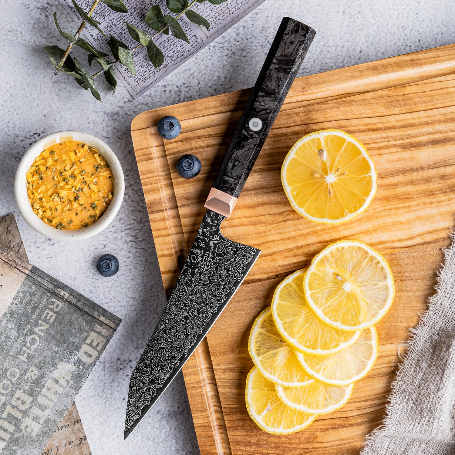 Decorative utility small knife on a wooden cutting board with sliced lemons and a bowl of yellow spice.