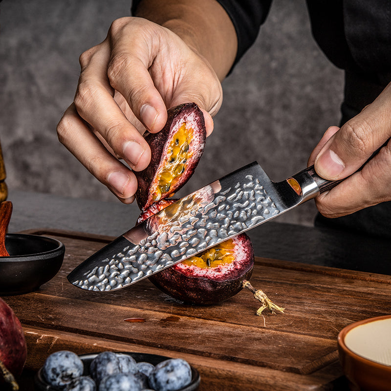 Japanese Chef cutting a passion fruit with a sharp and premium knife on a wooden surface